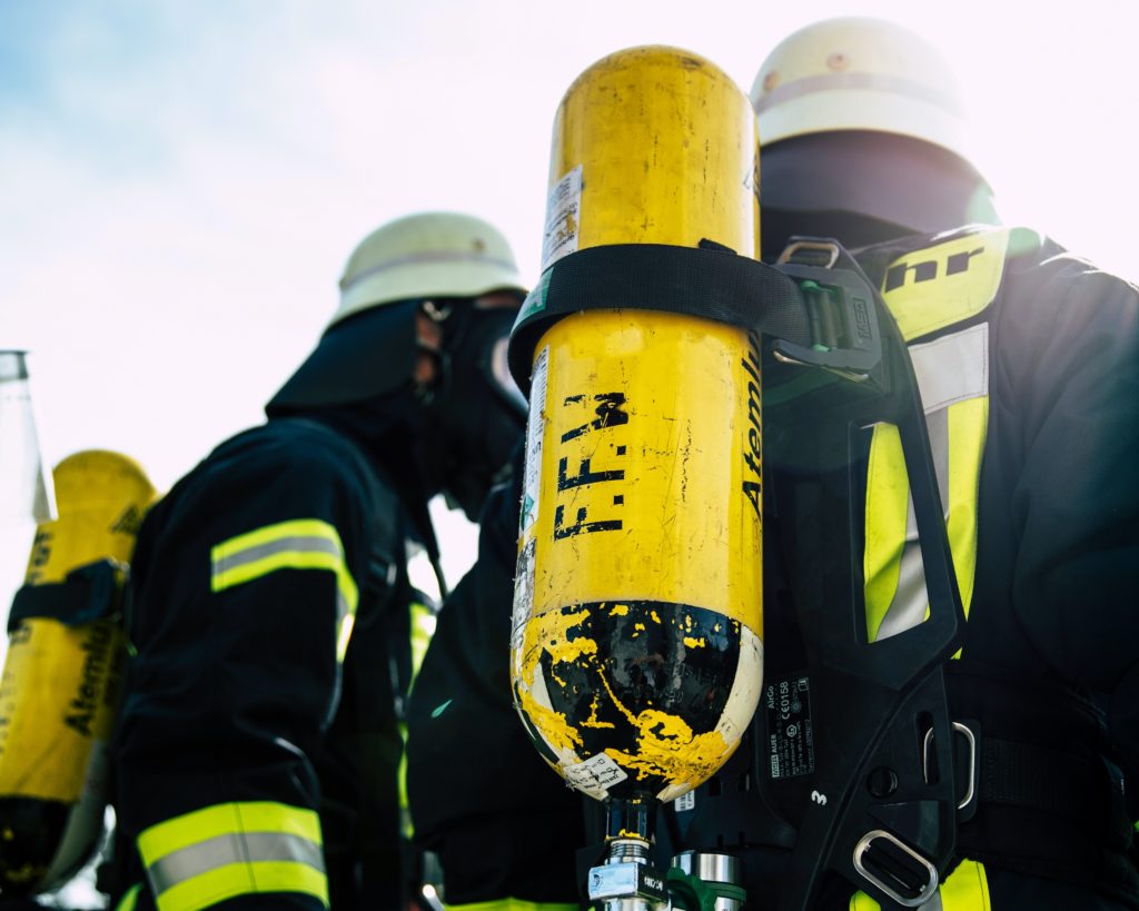 Rücken zweier Feuerwehrleute mit Atemschutzflaschen