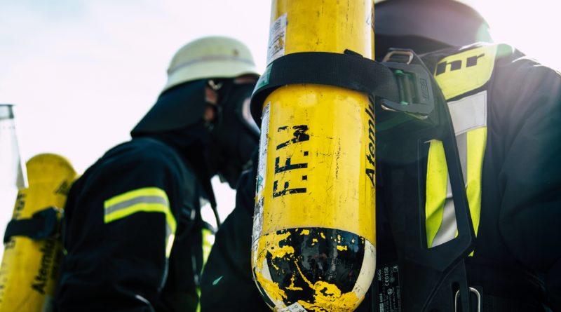 Rücken zweier Feuerwehrleute mit Atemschutzflaschen